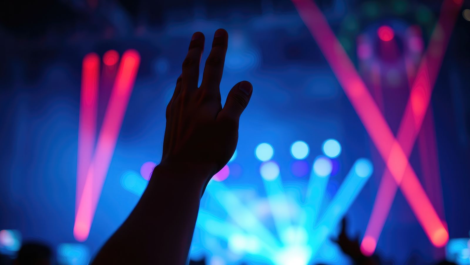 Mano alzada frente a un escenario iluminado
